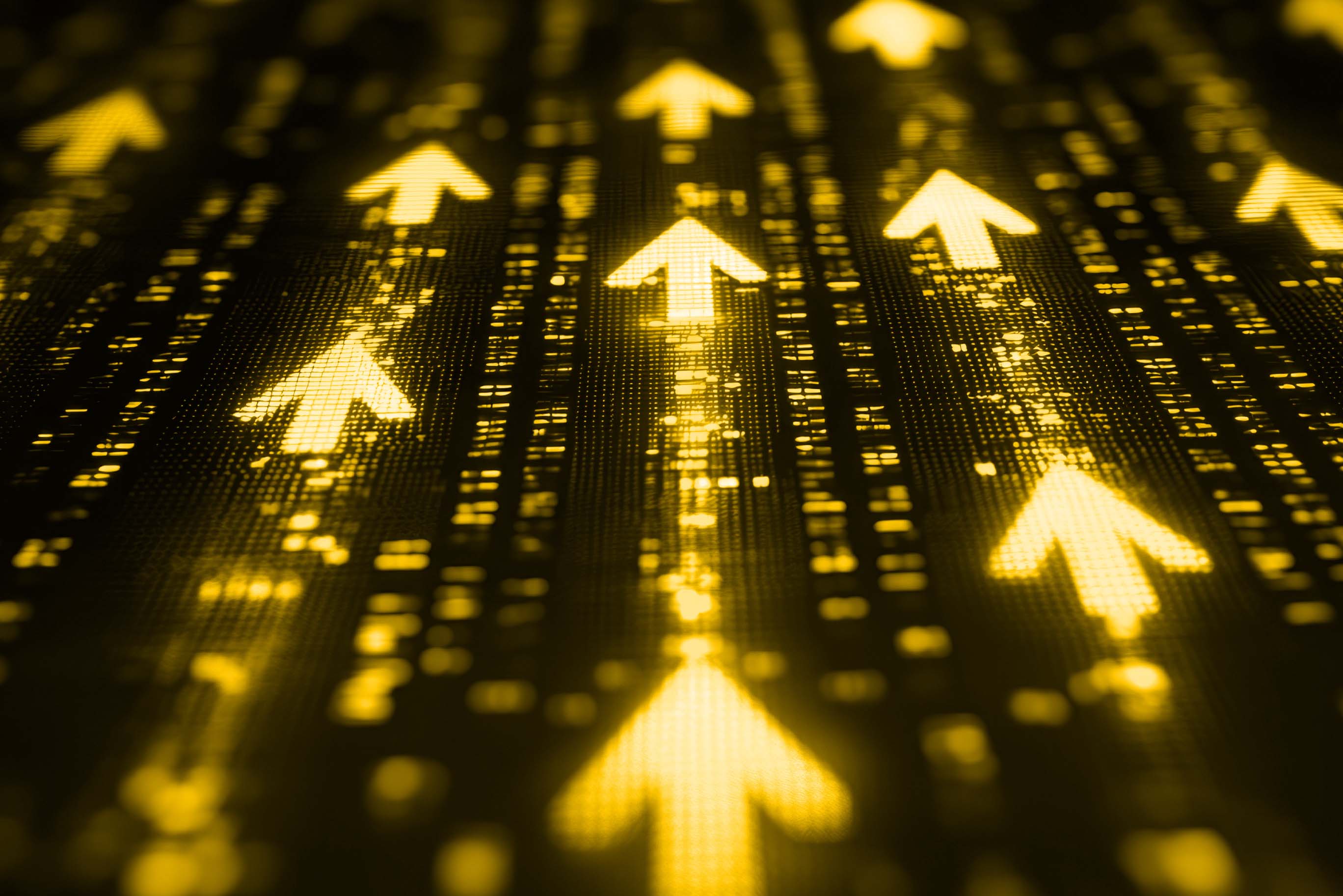 A field of glowing yellow arrows pointing upwards on a digital display, symbolizing growth, progress, and innovation.